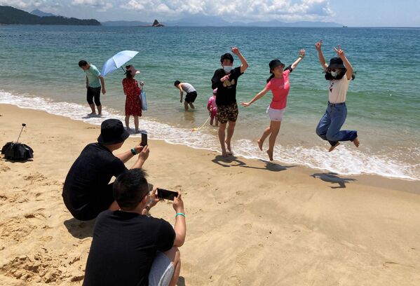 Люди в масках на пляже во время фотогарфирования в Китае  - Sputnik Кыргызстан