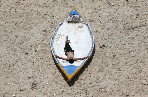 Палестинский юноша во время отдыха на пляже в Газе  - Sputnik Кыргызстан