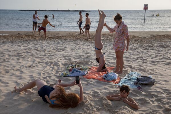 Люди во время отдыха на пляже в Тель-Авиве  - Sputnik Кыргызстан