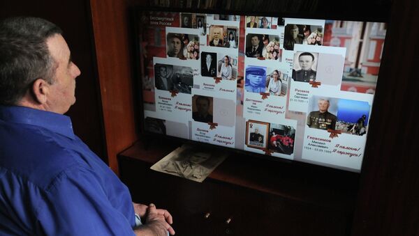 Мужчина смотрит онлайн-трансляцию акции Бессмертный полк  - Sputnik Кыргызстан