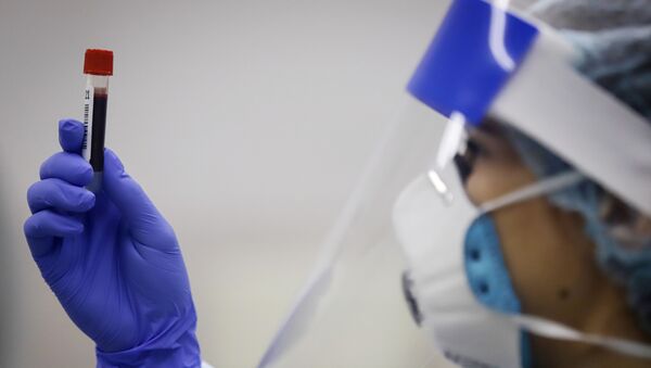 Медицинский работник держит в руках пробирку с биоматериалом для тестирования на наличие антител - Sputnik Кыргызстан