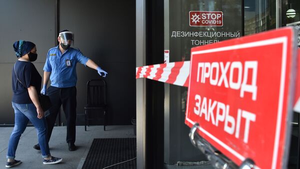 Охранник и посетитель в медицинских масках у входа в торговый центр после ослабления карантинных мер в Бишкеке. 25 мая 2020 года - Sputnik Кыргызстан