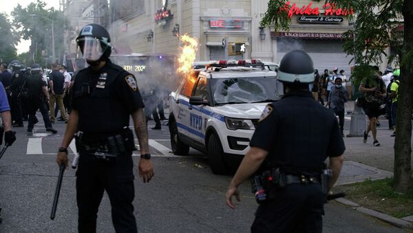 Сотрудники полиции Нью-Йорка у горящей машины, во время массовых беспорядков из-за смерти афроамериканца Джорджа Флойда. 30 мая 2020 года - Sputnik Кыргызстан
