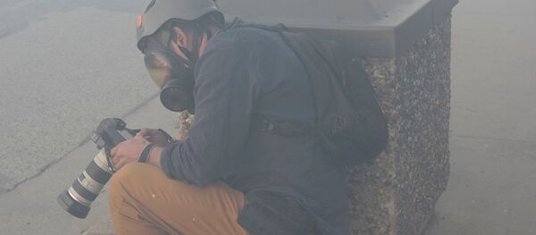 Фотожурналист Reuters  Carlos Barria во время применения слезоточивого газа в Миннеаполисе - Sputnik Кыргызстан