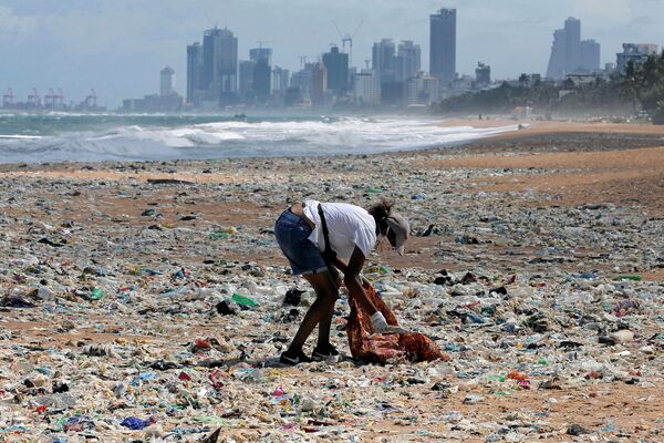 Волонтер собирает мусор на пляже в Коломбо, Шри-Ланка - Sputnik Кыргызстан