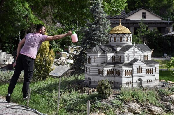Мужчина у макета Владимирского собора в Херсонесе в Бахчисарайском парке Крым в миниатюре на ладони - Sputnik Кыргызстан