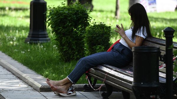 Девушка сидит на скамейке в парке. Архивное фото - Sputnik Кыргызстан