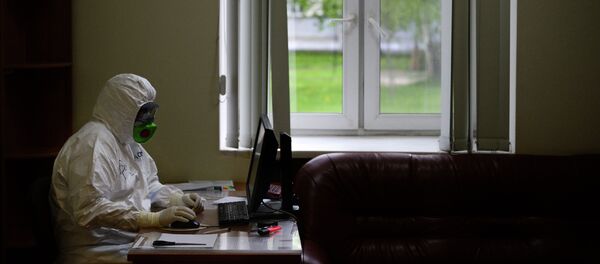 Врач в защитном костюме работает за компьютером. Архивное фото - Sputnik Кыргызстан