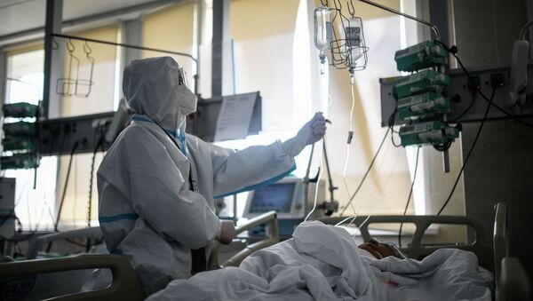 Врач проверяет капельницу у пациента в реанимации - Sputnik Кыргызстан