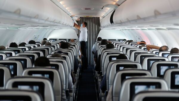 Пассажир носит защитную маску на самолете. Архивное фото - Sputnik Кыргызстан