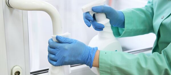 Девушка дезинфицирует ручку входной двери. Архивное фото - Sputnik Кыргызстан