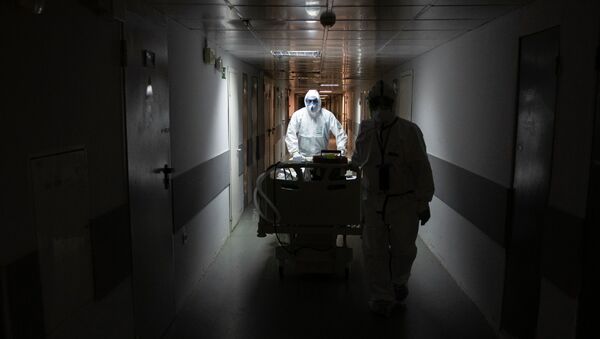 Медициналык кызматкерлер коронавирус менен ооруганды реанимация бөлүмүнө алпарып жатышат. Архив - Sputnik Кыргызстан