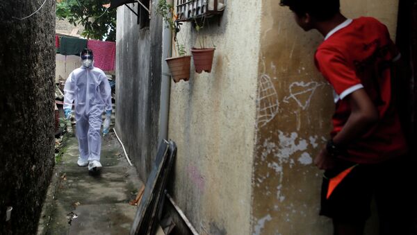 Медицинский работник идет по району трущоб во время проверки на наличие коронавирусной болезни в Мумбаи (Индия) - Sputnik Кыргызстан