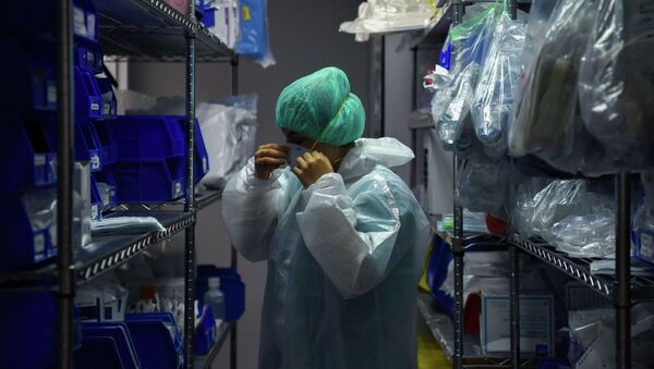 Медицинский работник надевает защитное снаряжение - Sputnik Кыргызстан