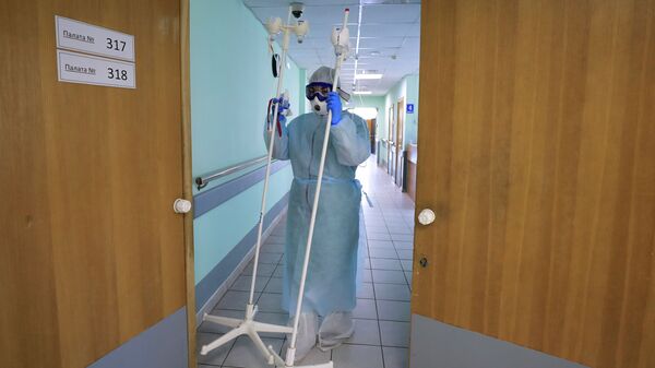 Медицинский работник несет штативы для капельниц. Архивное фото - Sputnik Кыргызстан