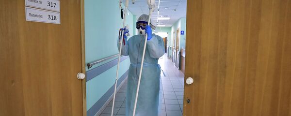 Медицинский работник несет штативы для капельниц. Архивное фото - Sputnik Кыргызстан