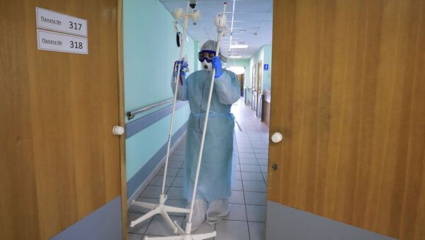 Медицинский работник несет штативы для капельниц. Архивное фото - Sputnik Кыргызстан