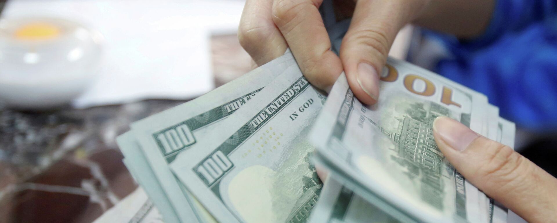 Сотрудник банка считает банкноты в долларах США. Архивное фото - Sputnik Кыргызстан, 1920, 12.03.2022
