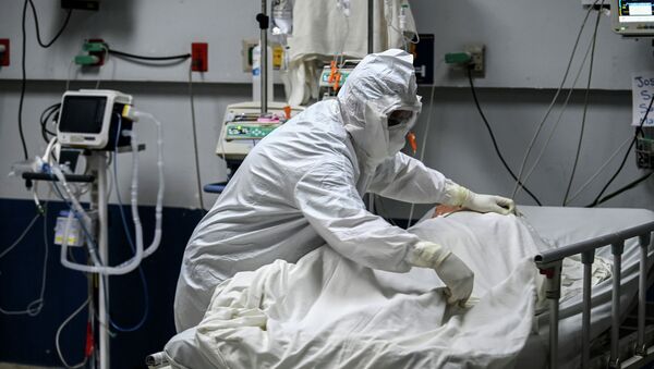 Медицинский работник поправляет постель пациента с коронавирусом - Sputnik Кыргызстан