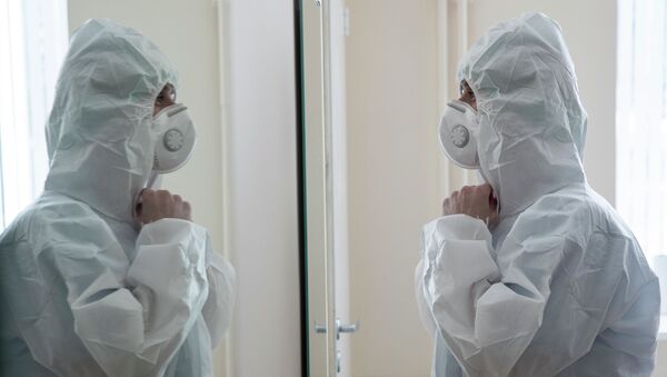 Медицинскай работник надевает защитный костюм. Архивное фото - Sputnik Кыргызстан