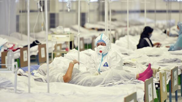 Күндүзгү стационарда бейтаптын жанында отурган медицина кызматкери. Архив - Sputnik Кыргызстан
