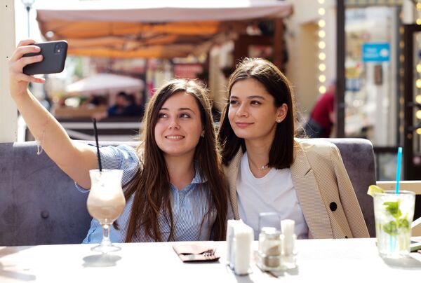 Девушки в летнем кафе на улице Старый Арбат после снятия карантина в Москве - Sputnik Кыргызстан