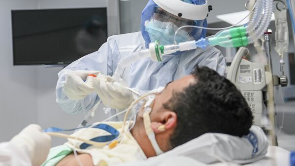 Медицинский сотрудник в больнице с пациентом инфицированным COVID-19. Архивное фото - Sputnik Кыргызстан